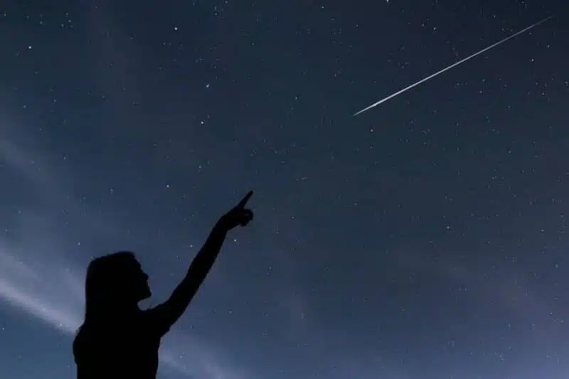 girl looking at the stars. girl making a wish by seeing a shooting star.